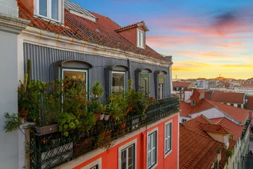 Crédence de cuisine en verre imprimé Ruelle étroite View from an alley with colorful residential buildings and terraces in the Alfama district overlooking the city of Lisbon Portugal at sunset. 