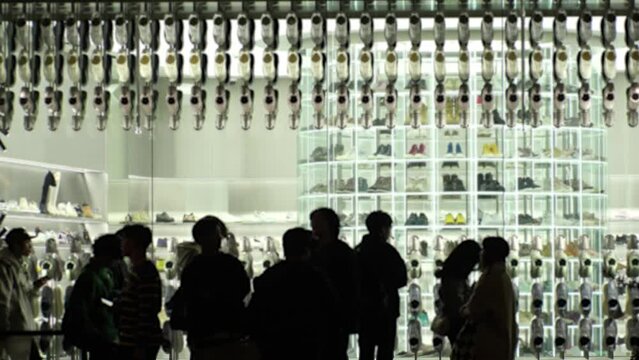 SHIBUYA, TOKYO, JAPAN - NOV 2023 : Exterior of sneaker shop at night. Youth culture fashion, street brand, apparel, clothing store and shopping concept video. Blurred time lapse shot.