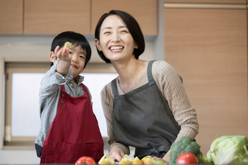 野菜やフルーツ大好きな子供　ママと一緒に料理をする子どものカメラ目線