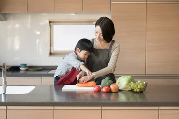 Parents and children having fun cooking in the kitchen together Image of a child helping a child...