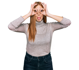 Young irish woman wearing casual clothes doing ok gesture like binoculars sticking tongue out, eyes looking through fingers. crazy expression.