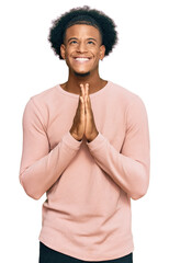 African american man with afro hair wearing casual clothes begging and praying with hands together...