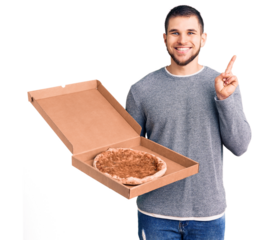 Young handsome man holding delivery italian pizza surprised with an idea or question pointing finger with happy face, number one