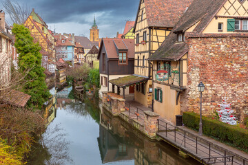 Traditional Alsatian half-timbered houses, church and river Lauch, Colmar, Alsace, France - obrazy, fototapety, plakaty