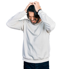 Middle age caucasian man wearing casual clothes suffering from headache desperate and stressed because pain and migraine. hands on head.
