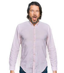 Middle age handsome man wearing business shirt afraid and shocked with surprise expression, fear and excited face.