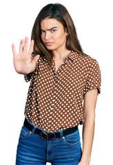 Young caucasian girl wearing casual clothes doing stop sing with palm of the hand. warning expression with negative and serious gesture on the face.