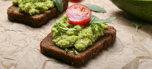 Tasty sandwich with guacamole and tomato on table, closeup