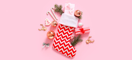 Beautiful Christmas sock with gifts and decorations on pink background