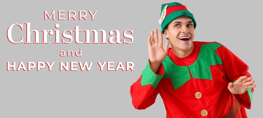 Handsome young man in elf's costume on grey background. Merry Christmas and Happy New Year