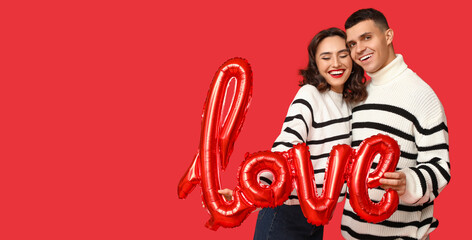 Loving young couple with balloon in shape of word LOVE on red background with space for text. Valentine's Day celebration