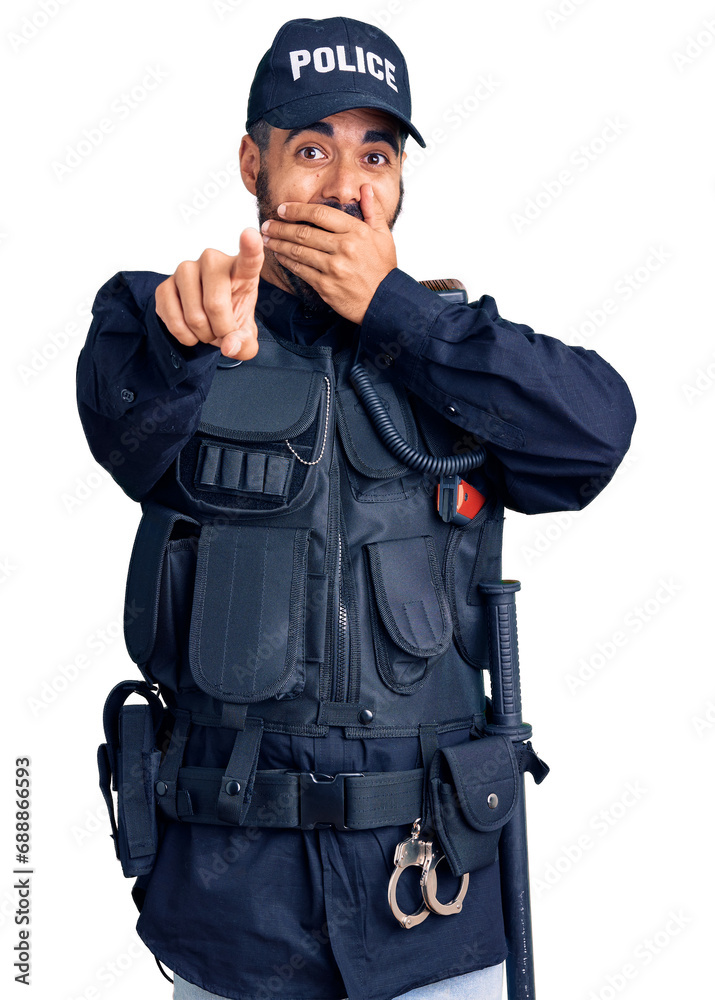 Sticker young hispanic man wearing police uniform laughing at you, pointing finger to the camera with hand o