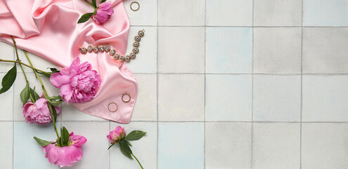 Stylish female jewelry, pink scarf and beautiful peony flowers on light tile background with space...