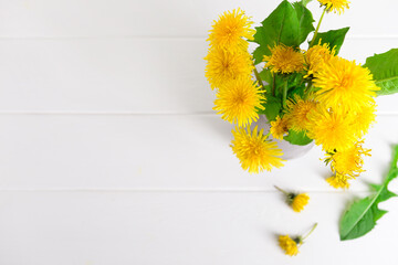 Yellow dandelion flowers on light wooden background