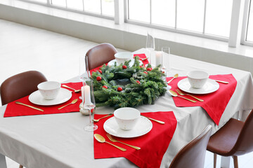 Christmas table setting with fir tree branches and burning candles
