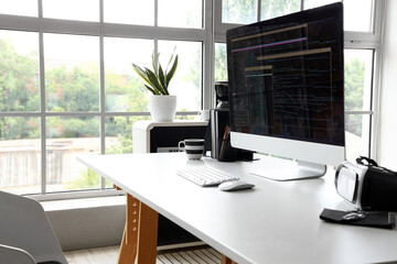 Computer monitor with programming code at workplace in office