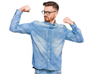 Young redhead man wearing casual denim shirt showing arms muscles smiling proud. fitness concept.