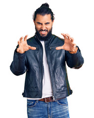 Young arab man wearing casual leather jacket smiling funny doing claw gesture as cat, aggressive...