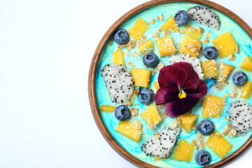 Delicious smoothie bowl with fresh fruits, blueberries, flower and oatmeal on white background, top view. Space for text