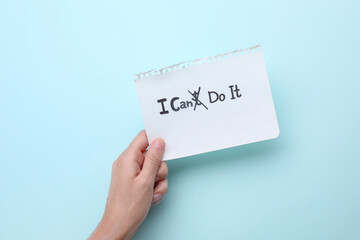 Motivation concept. Woman holding paper with changed phrase from I Can't Do It into I Can Do It by...