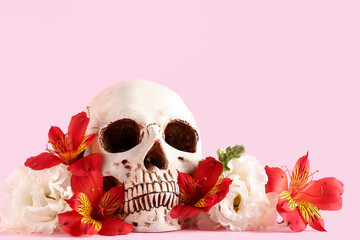 Human skull with beautiful flowers on pink background, closeup