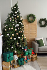 Interior of festive living room with Christmas tree and grey sofa