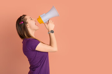 Young woman shouting into megaphone on beige background