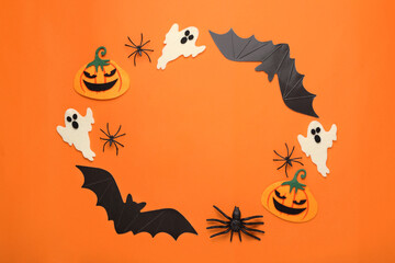 Frame made of cardboard bats, felt pumpkins, ghosts and spiders on orange background, space for text. Halloween celebration