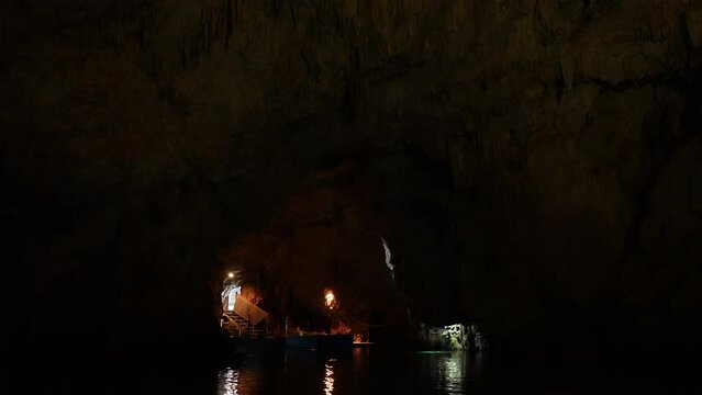 First point view from floating ship to Grotta dello Smeraldo just outside Amalfi, natural highlight along Amalfi Coast. Light from flashlight brightens dark interior of cave. Shooting in slow motion.