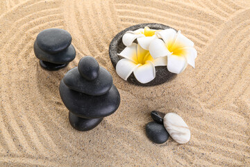 Fototapeta na wymiar Zen stones and flower on sand background