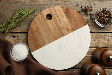 Cutting board and spices on old wooden table, flat lay
