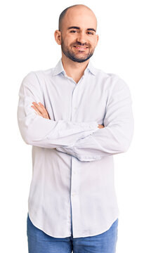 Young handsome man wearing elegant shirt happy face smiling with crossed arms looking at the camera. positive person.
