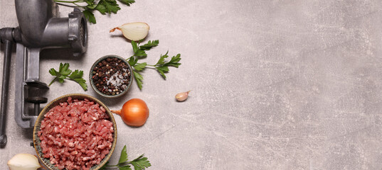 Manual meat grinder, beef mince, peppercorns, onion and parsley on light grey table, flat lay. Banner design with space for text