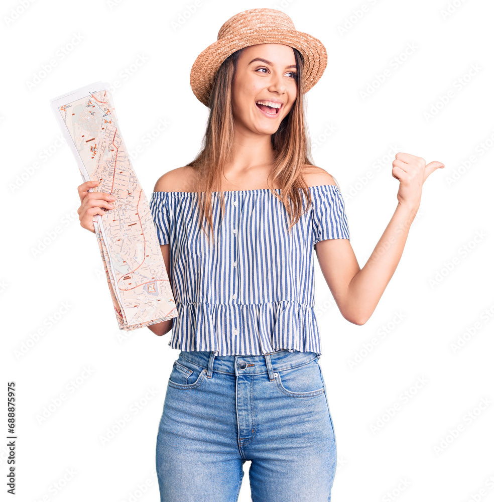 Wall mural Young beautiful girl wearing hat holding city map pointing thumb up to the side smiling happy with open mouth