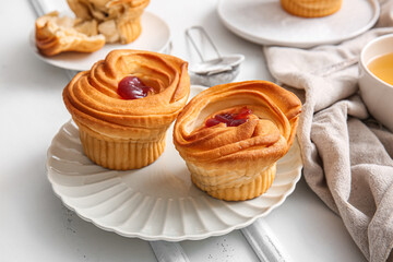 Plate of tasty cruffins with jam on white wooden background