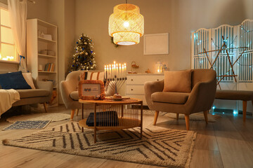 Interior of living room decorated for Hannukah with armchairs and table at night