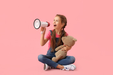 Little girl with megaphone and teddy bear sitting on pink background - obrazy, fototapety, plakaty