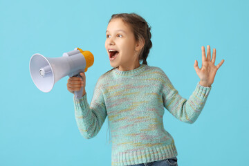 Little girl with megaphone screaming on blue background