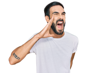 Young hispanic man wearing casual white t shirt shouting and screaming loud to side with hand on mouth. communication concept.