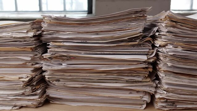 Stack business paper on desk, paperwork in office. Piled heap high documents folders
