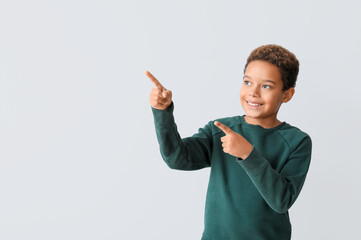 Little African-American boy pointing at something on white background