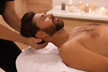 Obraz na płótnie Canvas Man receiving professional neck massage in spa salon