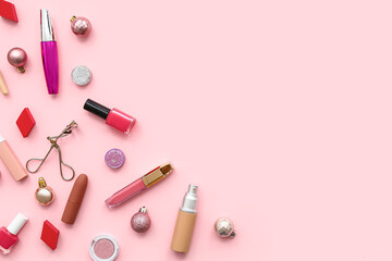 Different decorative cosmetics and Christmas balls on pink background