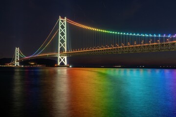Fototapeta na wymiar レインボーカラーにライトアップされた明石海峡大橋の情景