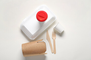 Takeaway paper cups, containers and cutlery on white background