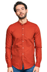 Young hispanic man wearing casual clothes relaxed with serious expression on face. simple and natural looking at the camera.