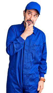 Middle age handsome man wearing mechanic uniform thinking worried about a question, concerned and nervous with hand on chin