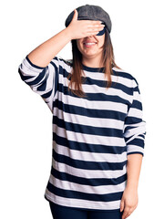 Young beautiful brunette woman wearing burglar mask smiling and laughing with hand on face covering eyes for surprise. blind concept.