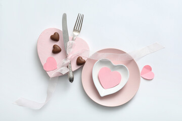 Beautiful table setting with candies for Valentine's Day on white background