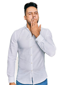 Young arab man wearing casual clothes bored yawning tired covering mouth with hand. restless and sleepiness.